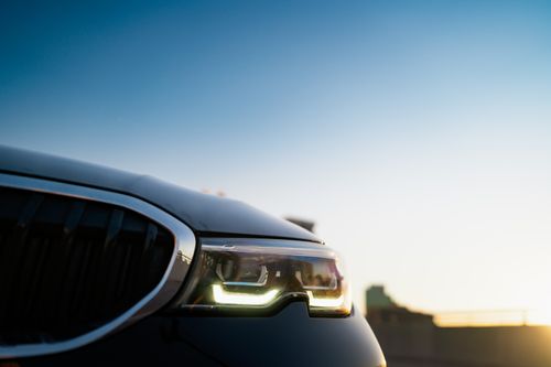 Free Detailed capture of a car's headlight during sunset, emphasizing the modern design and sleek lines. Stock Photo