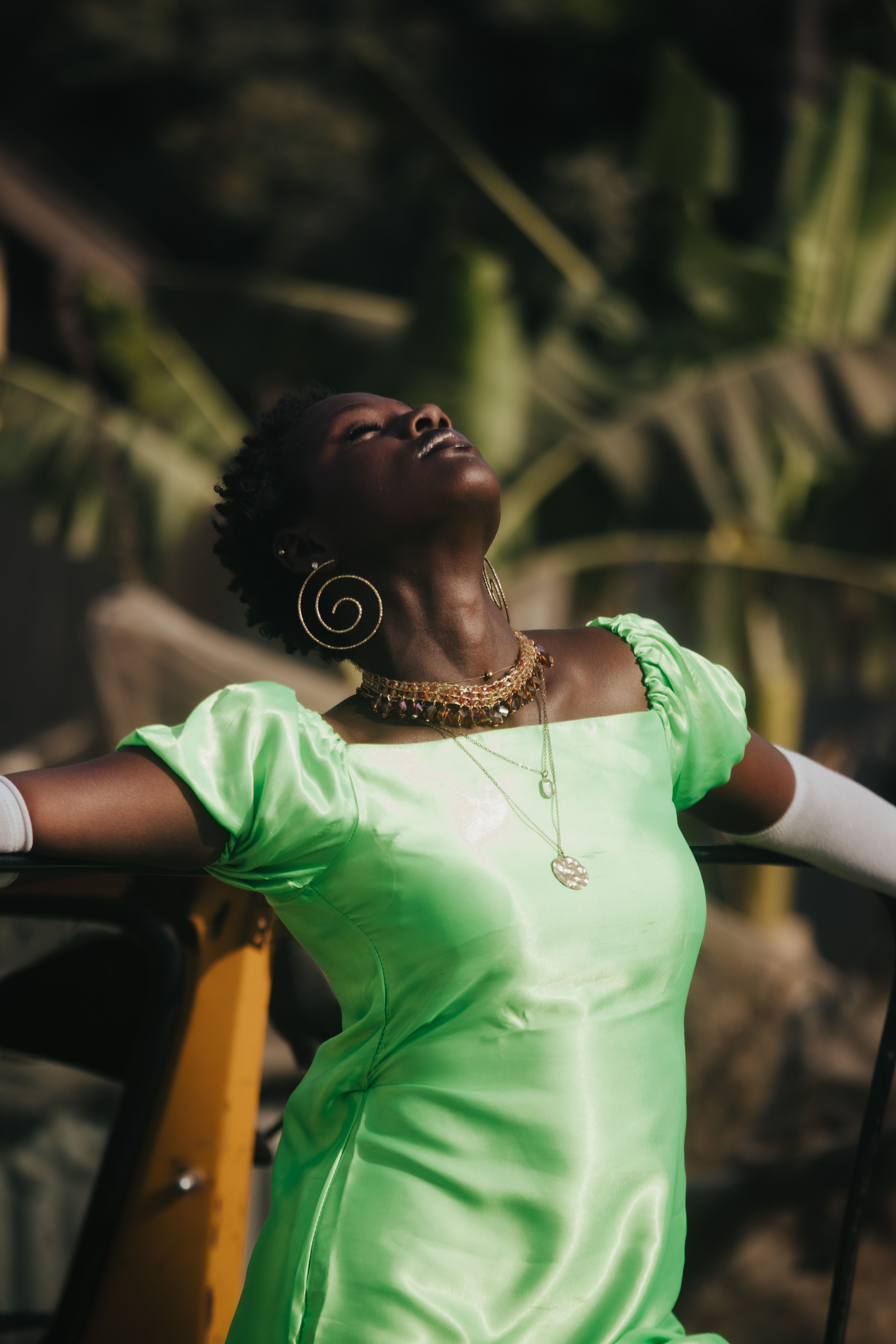 Elegant Woman Posing Outdoors in Vibrant Green Dress · Free Stock Photo