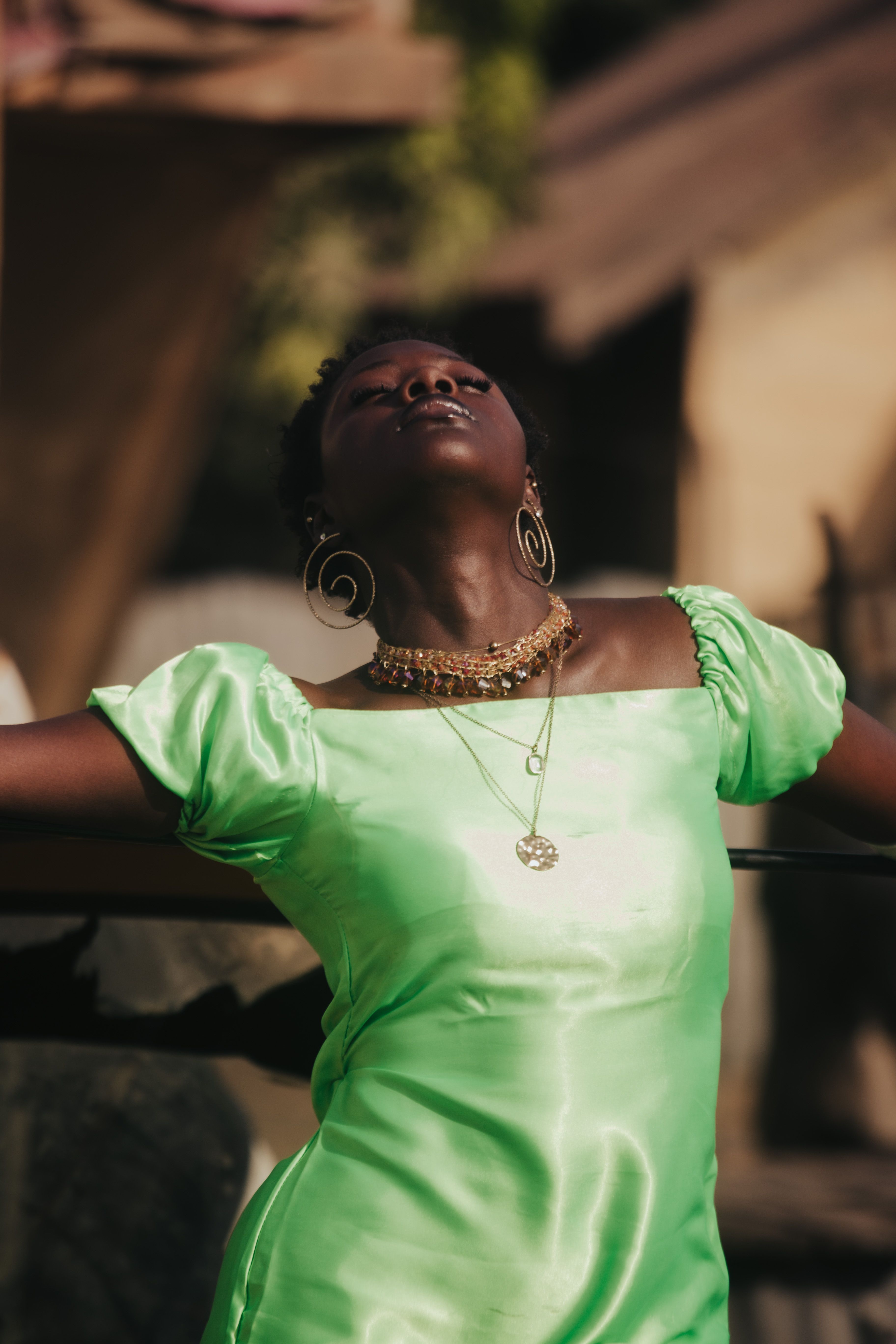 Elegant Woman in Green Dress Enjoying Sunlight · Free Stock Photo