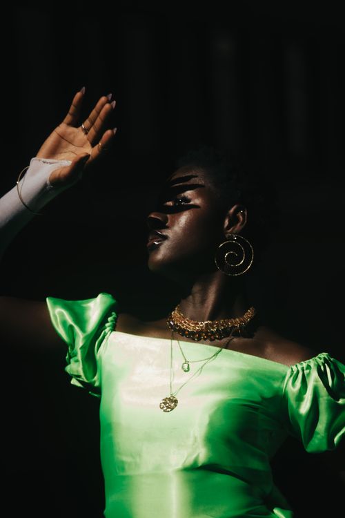 Free Stylish portrait of a woman in vibrant attire under dramatic lighting. Stock Photo
