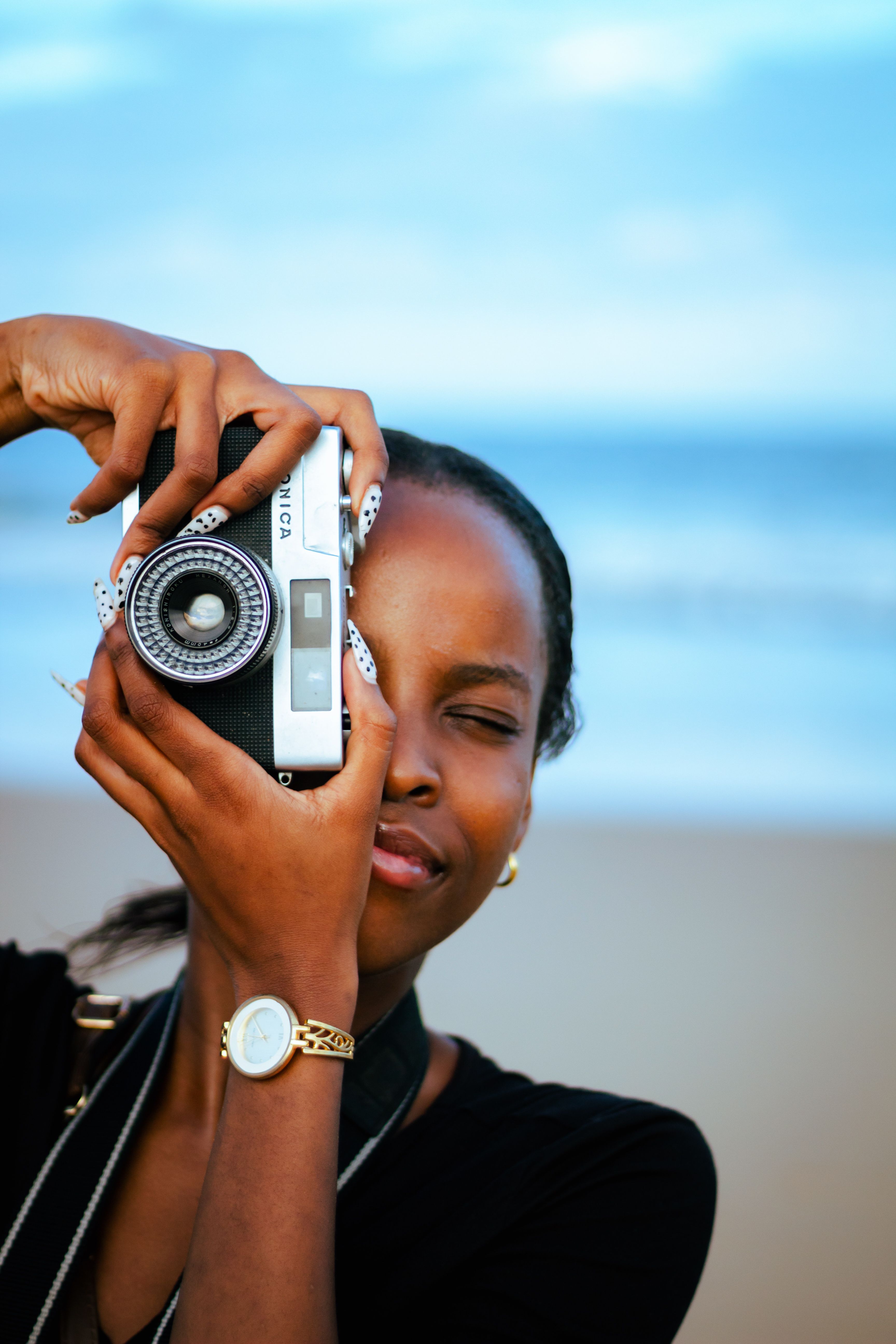 A young photographer with a camera near the ocean in Durban, South Africa.