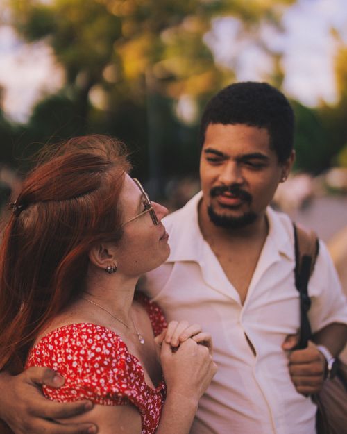 Free Couple sharing a tender moment outdoors in warm sunlight. Stock Photo
