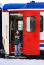 Young Woman Standing on Train in Winter Snow