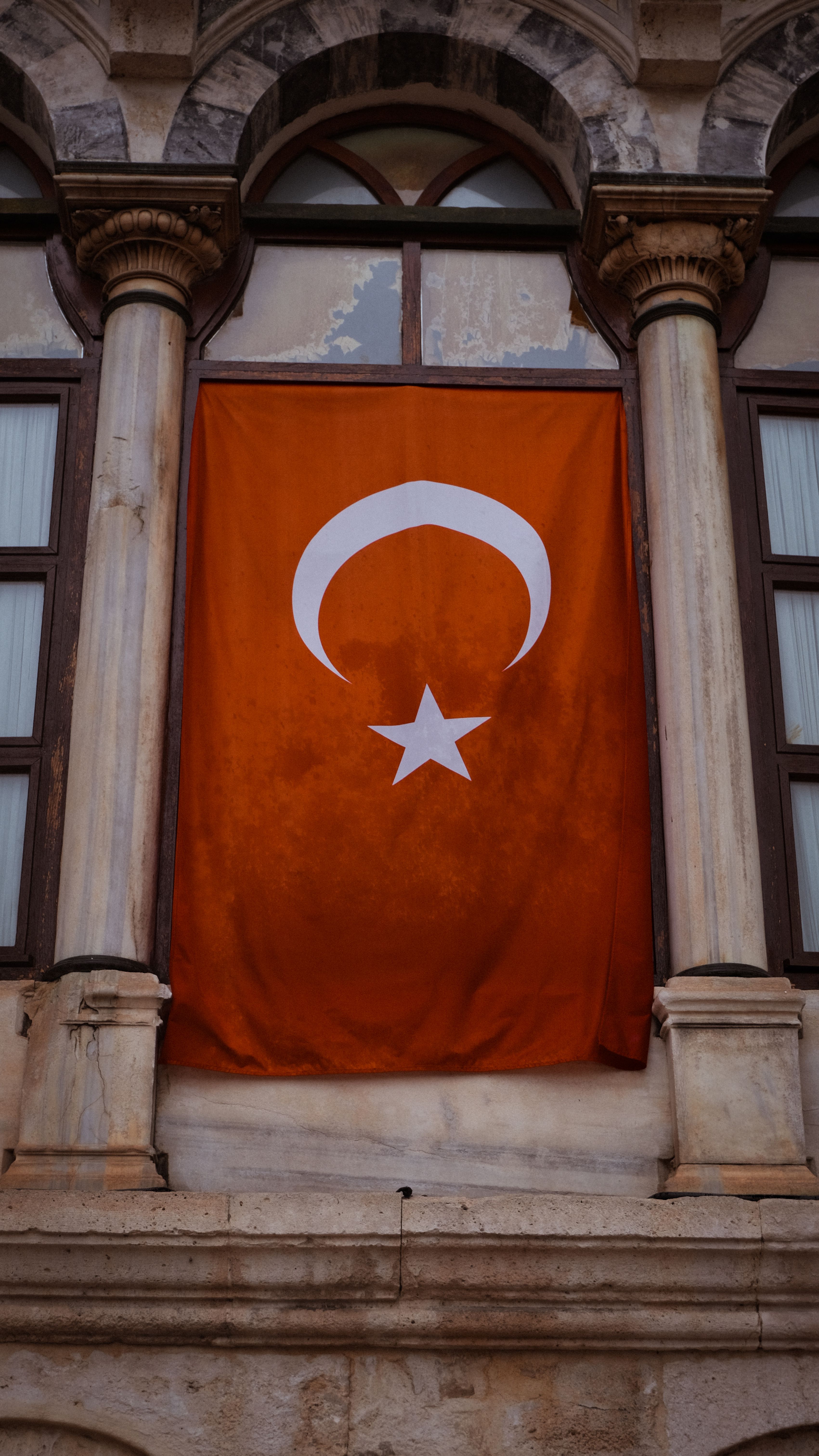 Turkish flag displayed on a historic building facade in Istanbul, showcasing national pride.