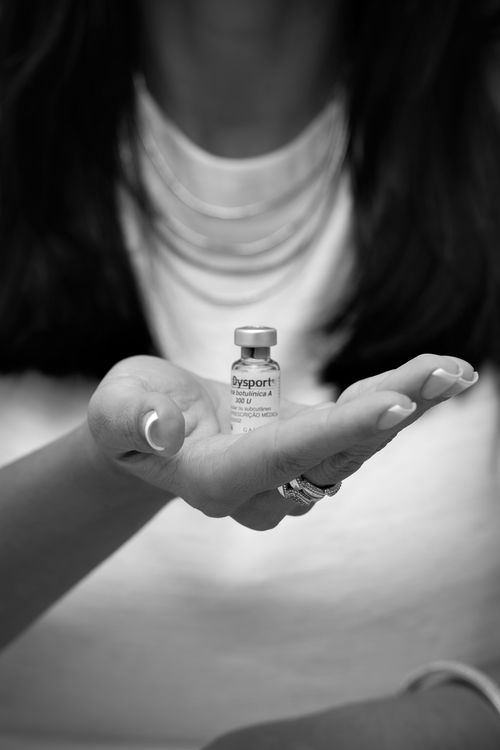 Free Monochrome photo of a person holding a Dysport vial, focusing on wellness. Stock Photo