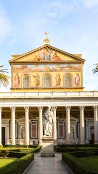 Front view of Basilica Papale di San Paolo fuori le Mura in Rome with decorative facade and garden.