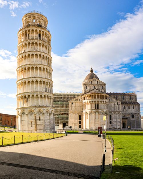 Free The iconic Leaning Tower of Pisa and Pisa Cathedral under a bright blue sky. Stock Photo