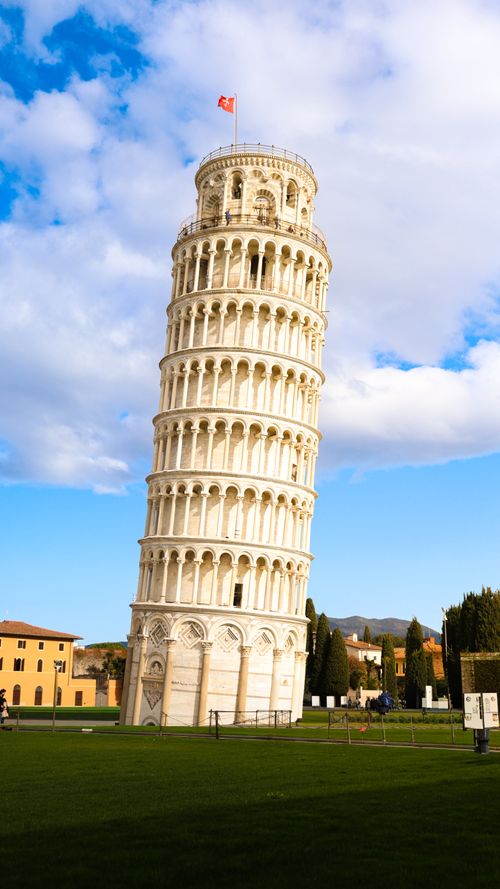 Free Iconic Leaning Tower of Pisa in Tuscany, Italy, captured under a vibrant blue sky. Stock Photo