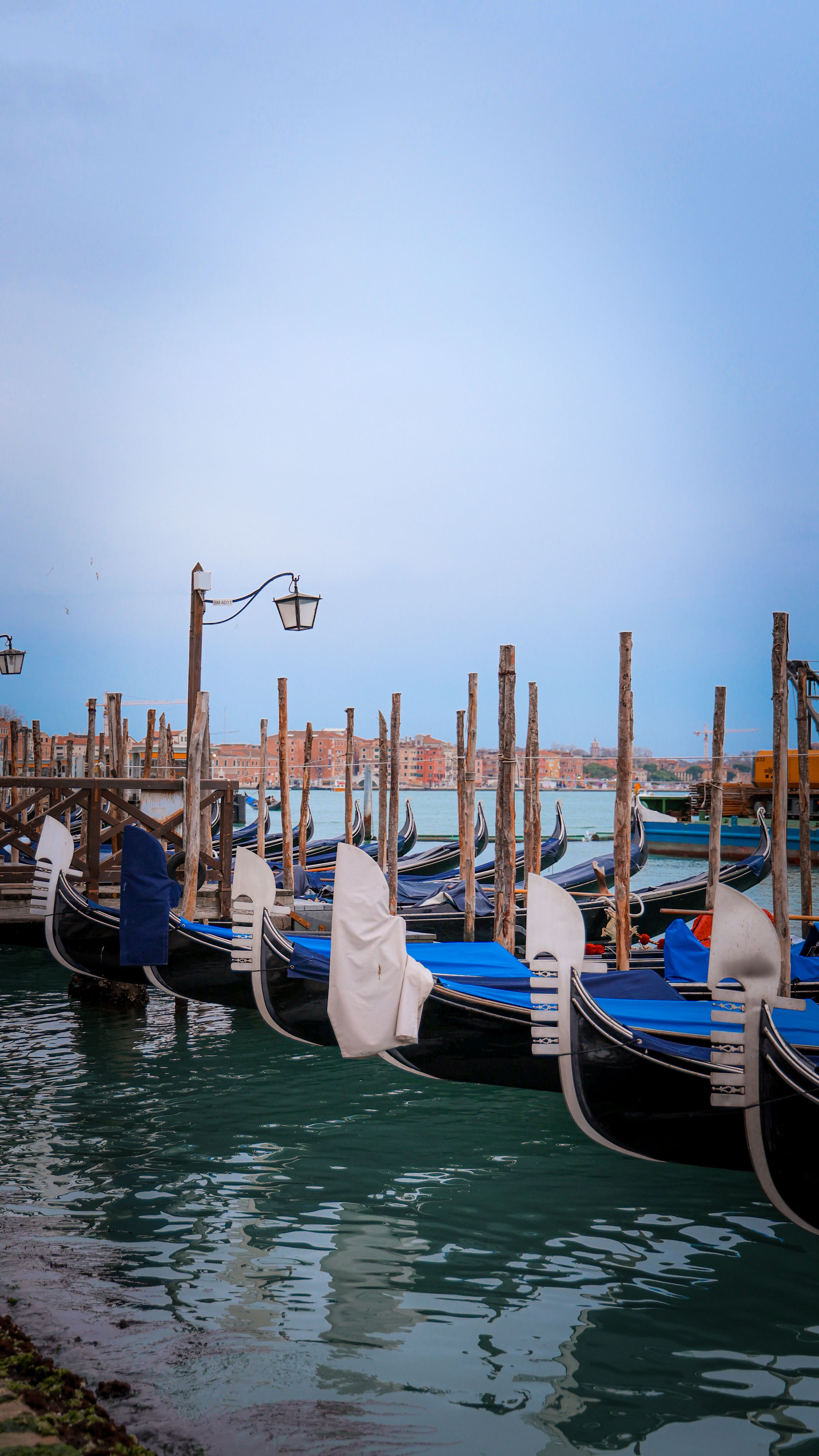 Row of gondolas on the serene Venetian canal at sunrise, Italy.