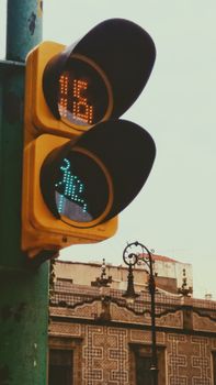 Vintage style urban traffic light with pedestrian signal in city setting.