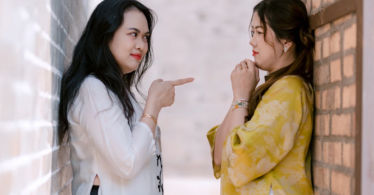 Two women interact in a narrow alleyway with a playful stance, bringing attention to their expressions.
