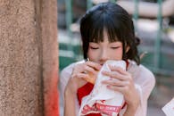 Young Woman Enjoying a Street Snack Outdoors
