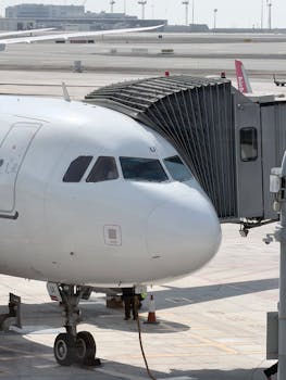 Modern airplane at Abu Dhabi airport gate in daylight, ready for boarding.