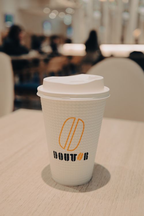 Free A coffee cup with branding in a cozy café setting, perfect for lifestyle themes. Stock Photo