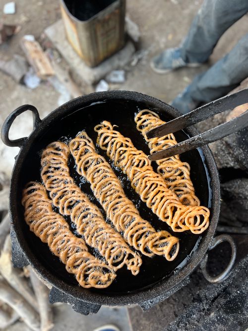 Free Close-up of chakli being fried outdoors in a pan. Indian street food cooking process. Stock Photo