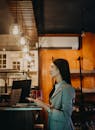 一名身着西装的女子在时尚咖啡店的柜台点单，店内灯光柔和