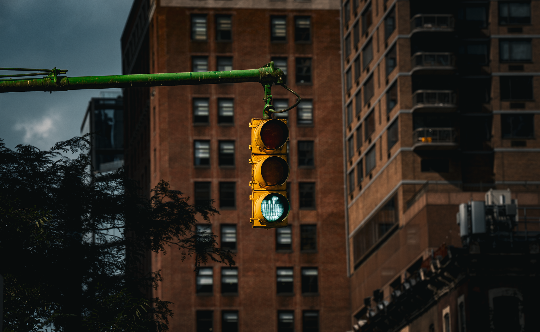Classic New York traffic light with green signal in front of urban buildings.