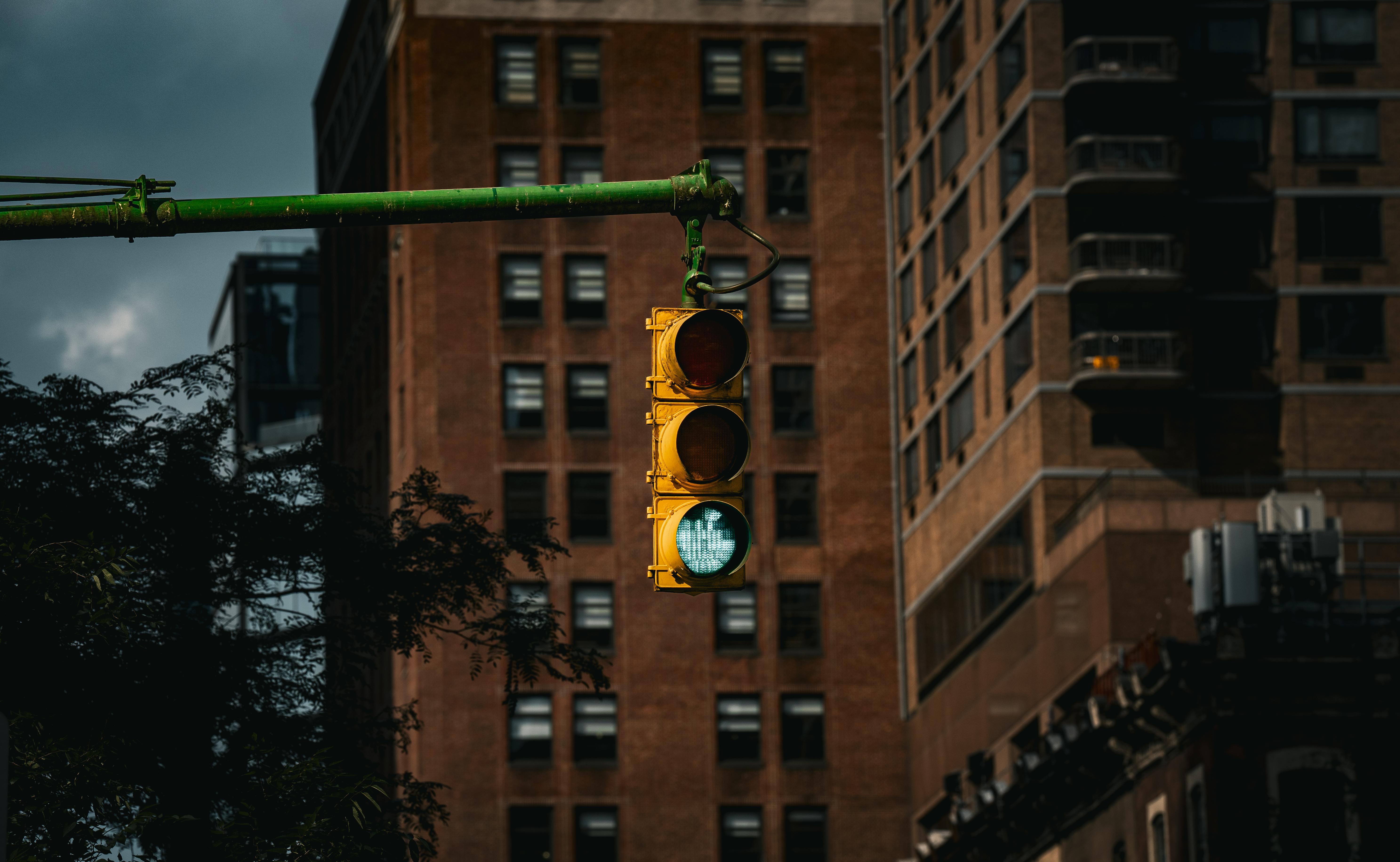 Kostenlos Klassische New Yorker Ampel mit grünem Signal vor städtischen Gebäuden. Stock-Foto