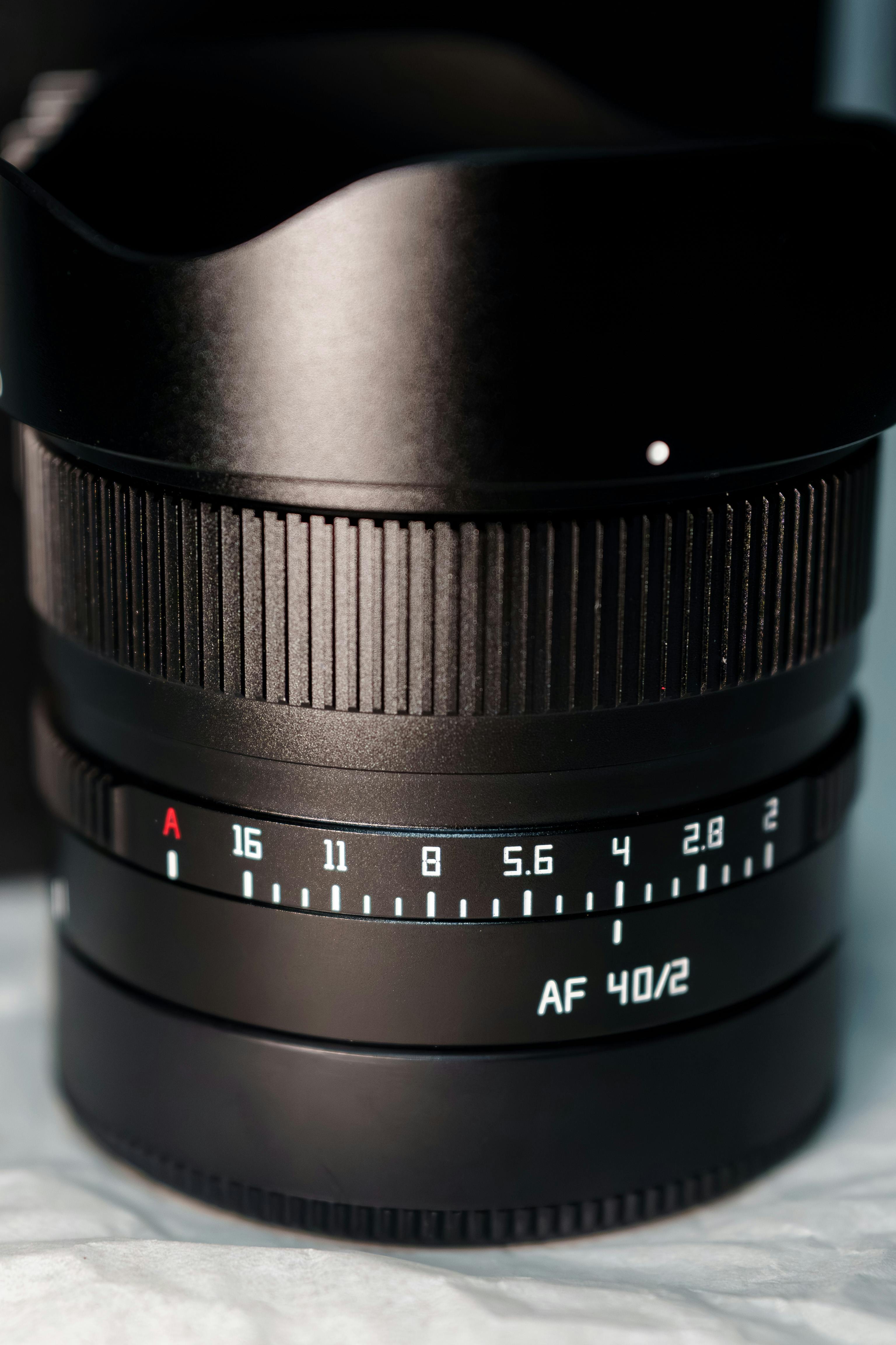Detailed view of an AF 40mm F2 camera lens with visible aperture settings in soft lighting.