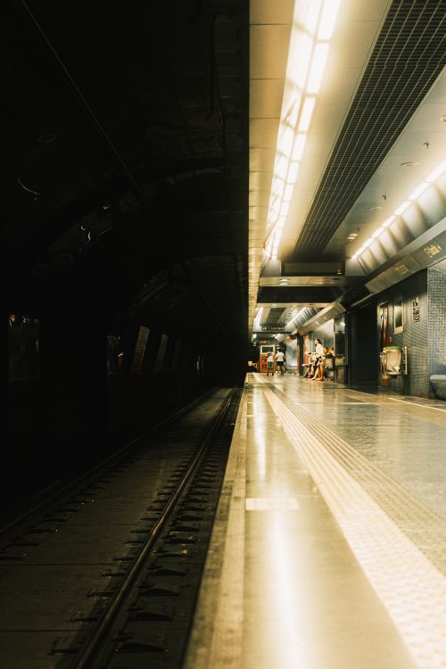 Free Dimly lit subway station with empty tracks and illuminated platform. Stock Photo