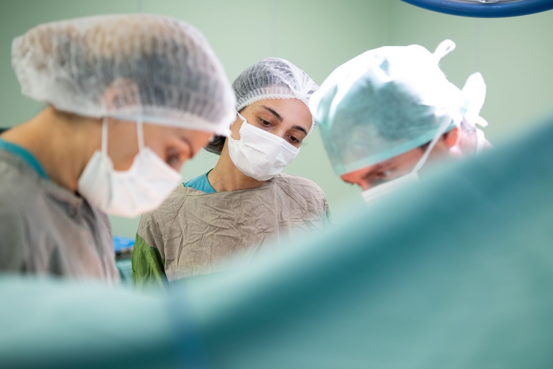 Focused medical team performing surgery in a sterile operating room environment with precision and care.