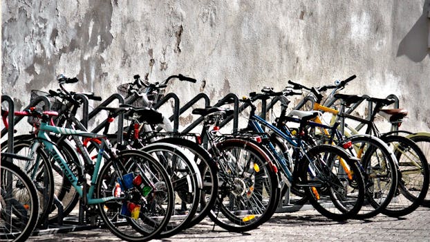 A vibrant display of bicycles parked against a weathered wall in daylight.
