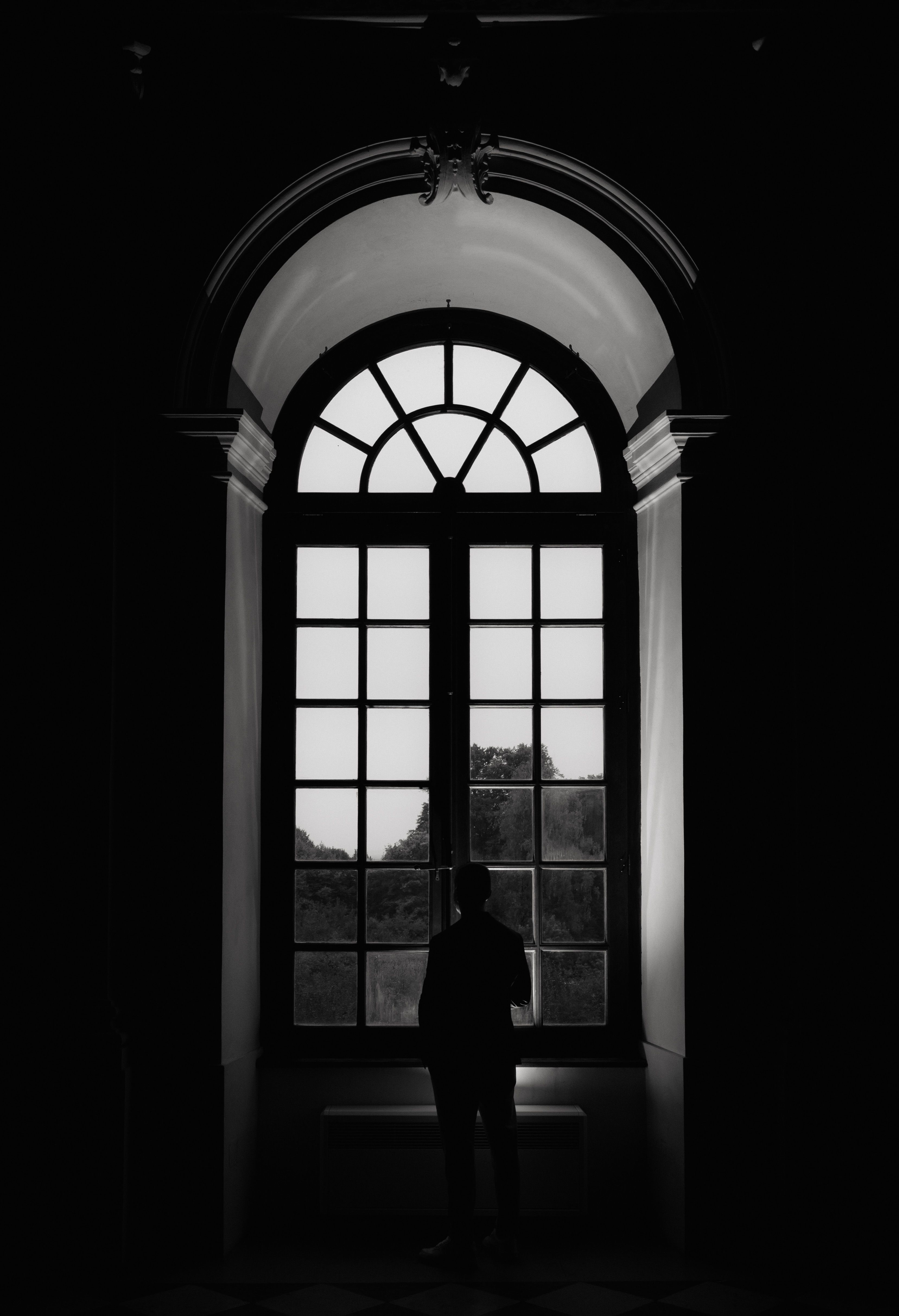 Silhouette of a Person Standing in Front of a Window · Free Stock Photo