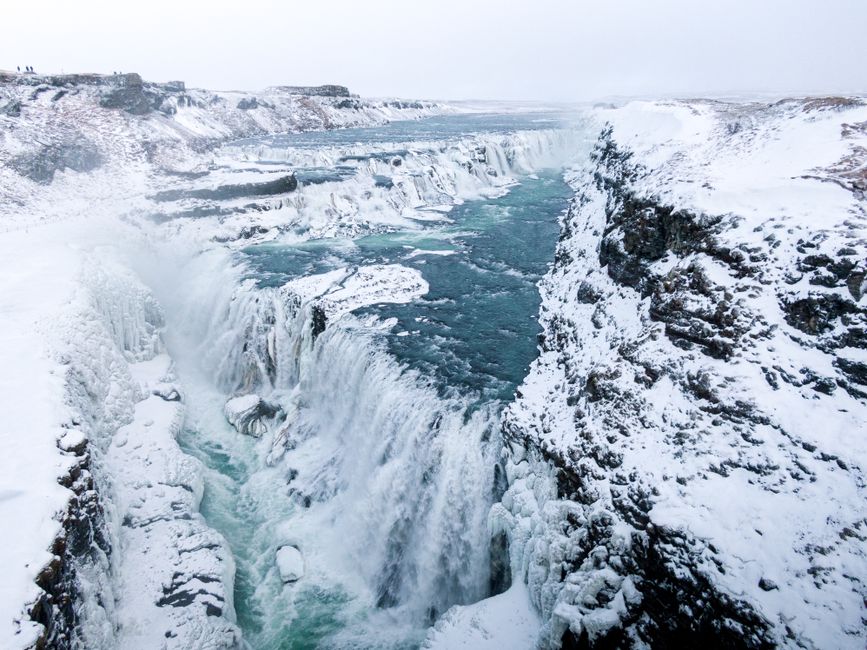 Unforgettable Landmarks from Above: Helicopter Tour with 3 Landings Review Review 2026 - Breathtaking aerial shot of Gullfoss waterfall cascade amidst Iceland's icy winter landscape.