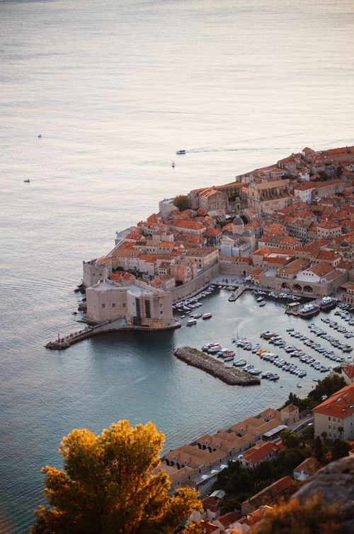 Free Stunning aerial view of Dubrovnik's Old Town and marina bathed in warm sunset light. Stock Photo
