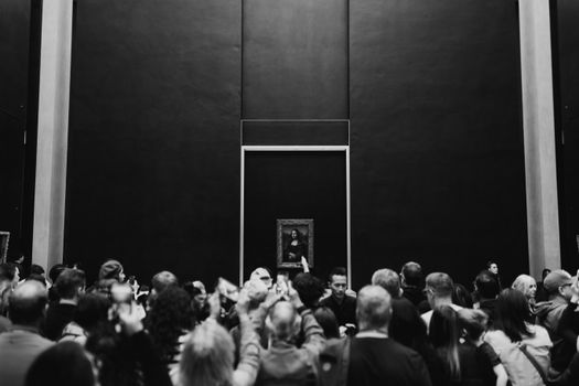 A large crowd gathers to view the Mona Lisa at the Louvre Museum in Paris, France.