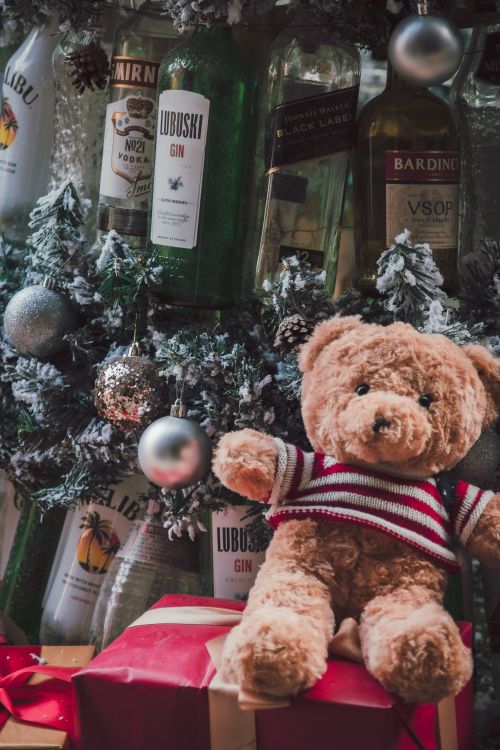 Free Cozy teddy bear with Christmas decorations and gifts, creating a festive holiday atmosphere. Stock Photo