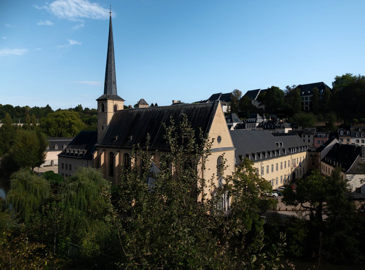 Biserică istorică din Luxembourg, înconjurată de verdeață sub cerul senin