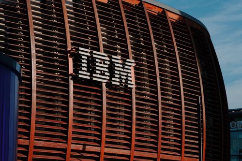 Free Close-up of IBM logo on a modern architectural facade under clear blue sky. Stock Photo