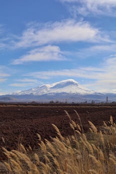 Scenic view of snow-capped Mount Hasan with a foreground of fields in Aksaray, Türkiye.