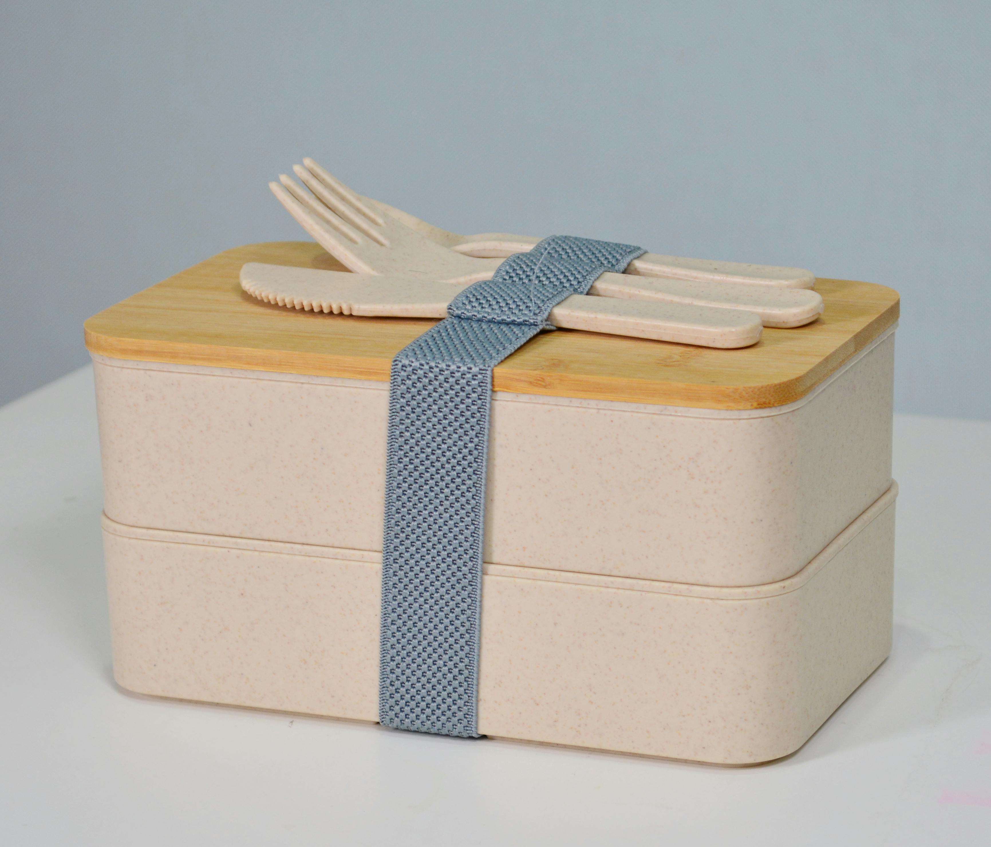 Stylish eco-friendly double layer bento box with bamboo lid and cutlery, perfect for healthy meals.