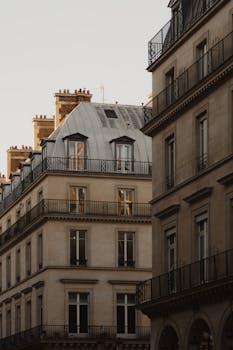 Classic Parisian buildings with wrought iron balconies at sunset, showcasing French urban elegance.
