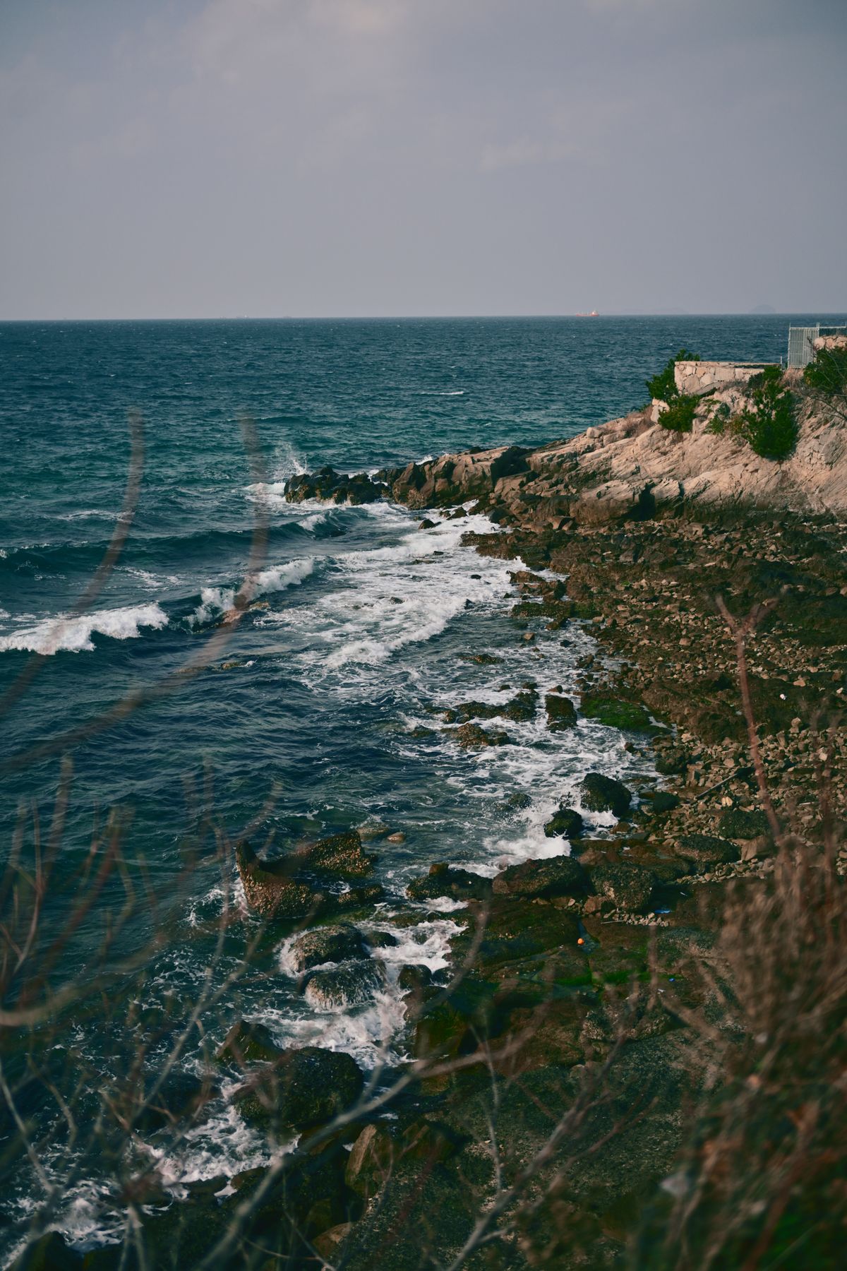 Waves breaking against a rocky coastline — photo by class SSS on Pexels