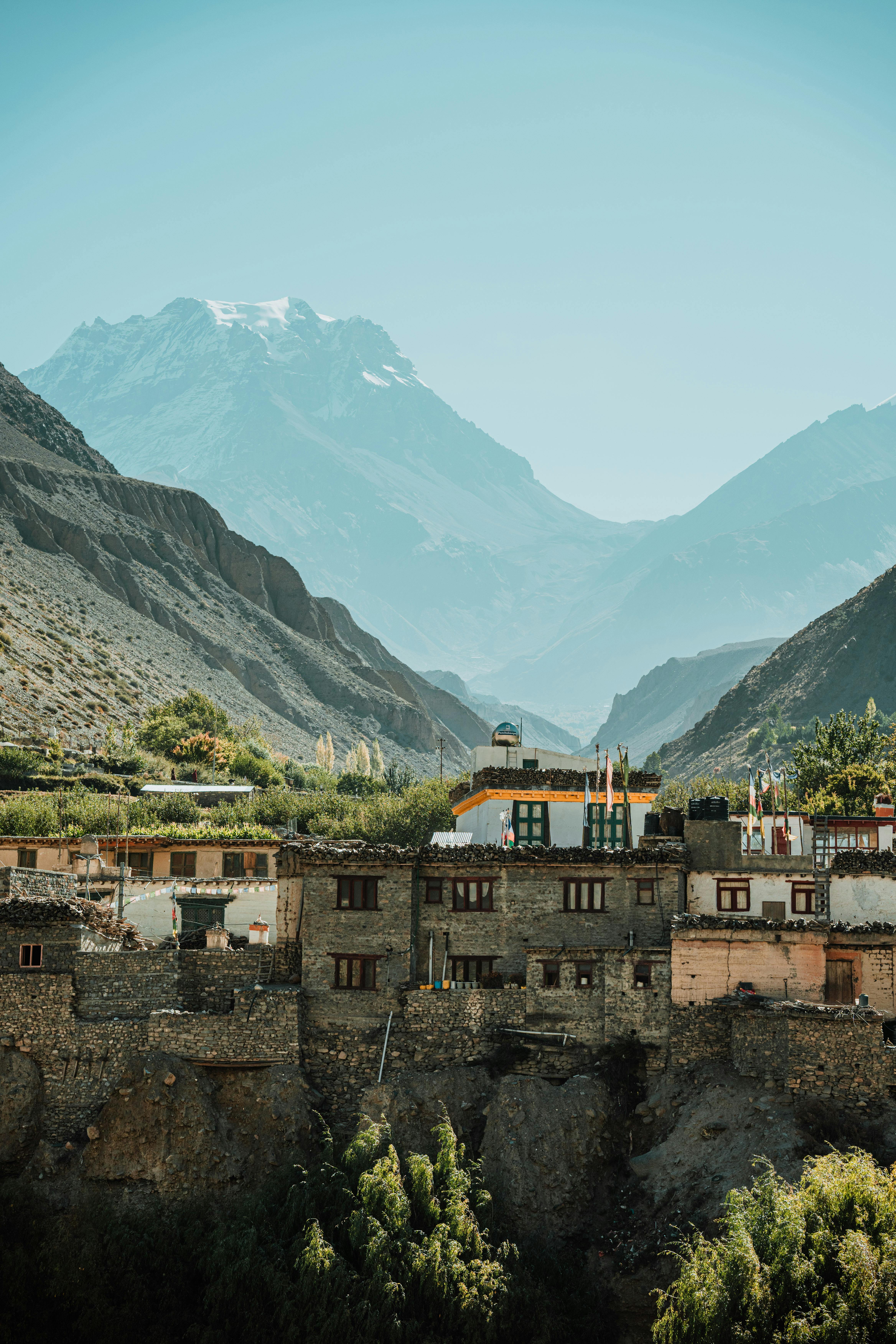 Charming village beneath majestic Himalayan mountains in clear daylight.