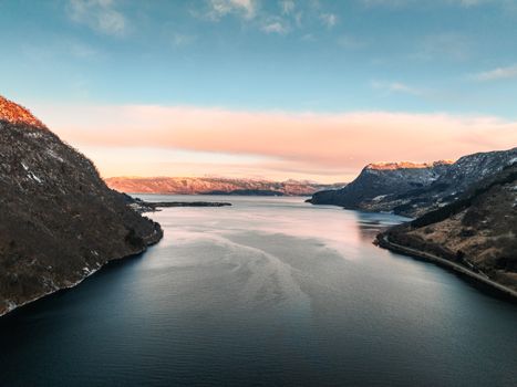 A breathtaking view of a Norwegian fjord during winter, showcasing a serene and vast landscape.