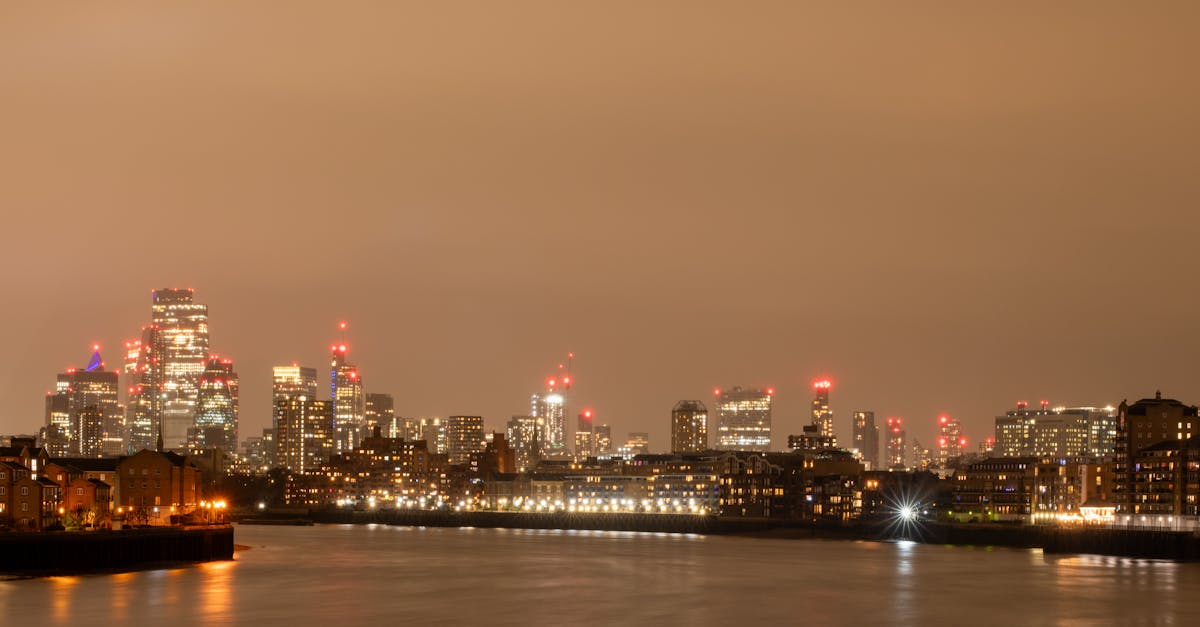 Stunning night view of London's skyline with the River Thames in the foreground, showcasing the city's illuminated towers.
