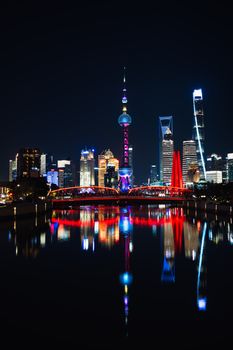 Stunning night view of Shanghai skyline with vibrant reflections in the river.