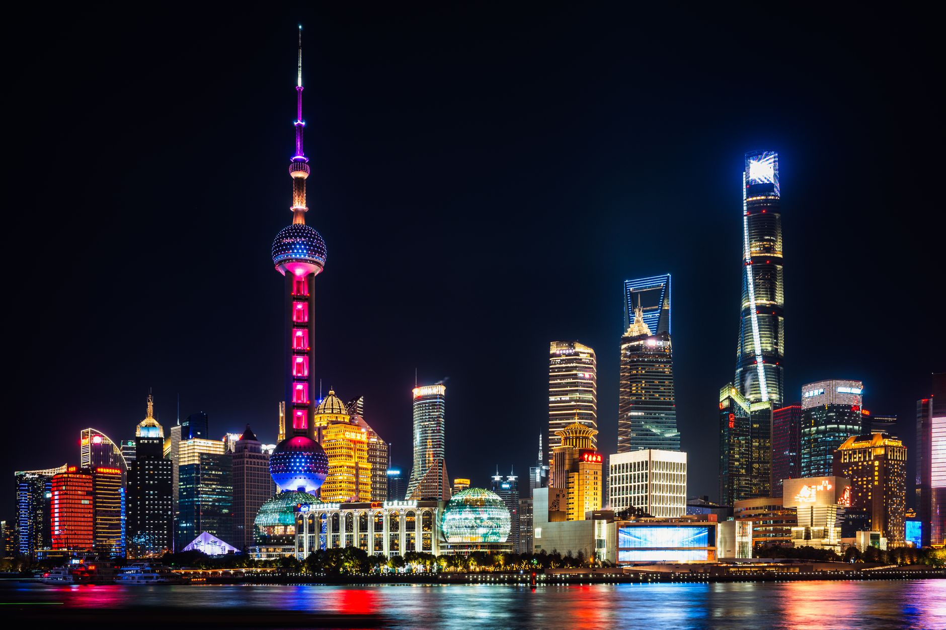 Vibrant night view of Shanghai's illuminated skyline featuring the iconic Oriental Pearl Tower.