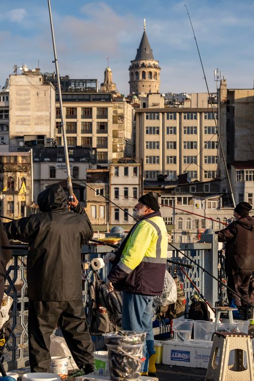 Free A scene of fishermen on the Galata Bridge with the historic Galata Tower in the background. Stock Photo