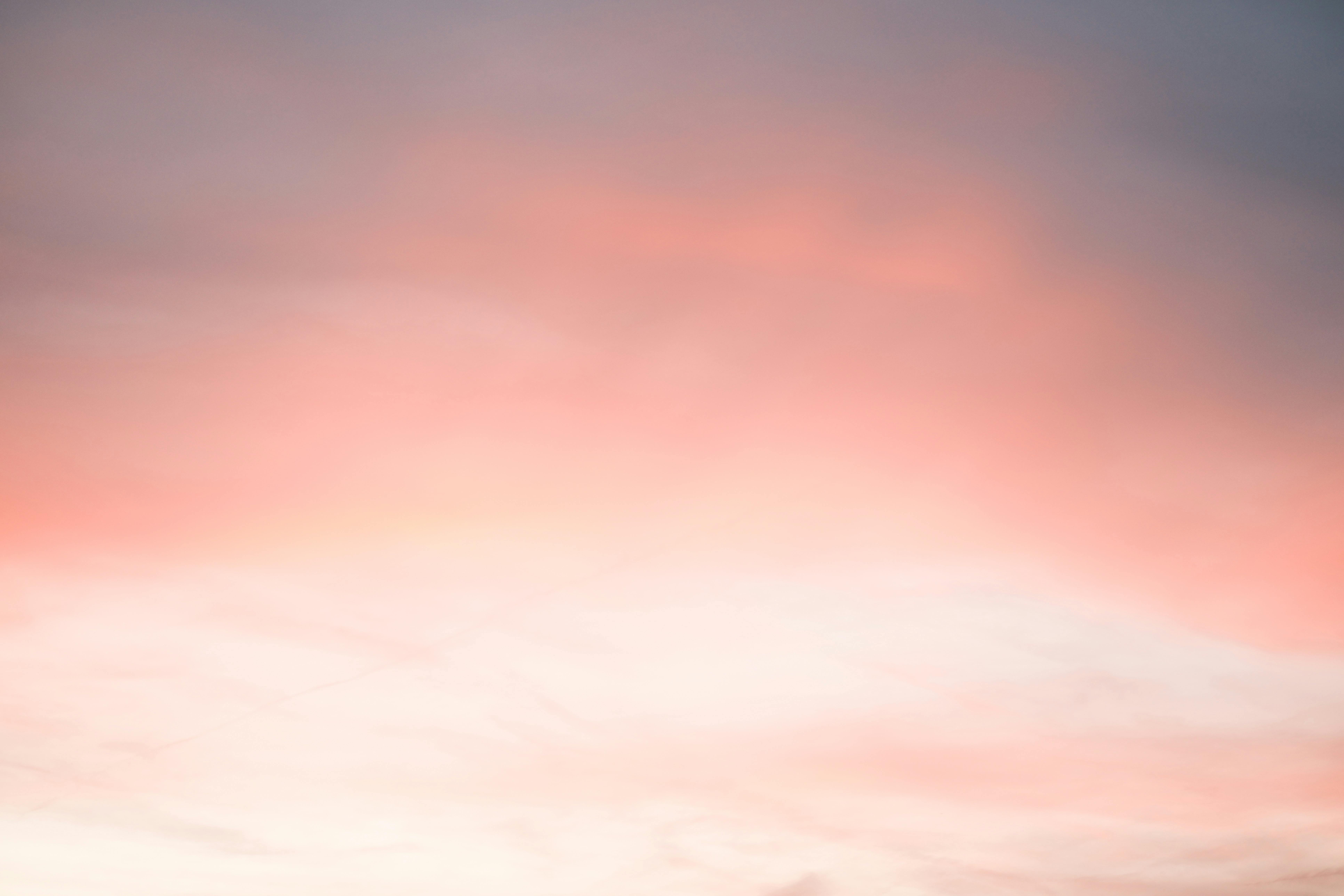 Kostnadsfria En lugnande gradient av rosa och orange nyanser i en solnedgångshimmel. Stock foto