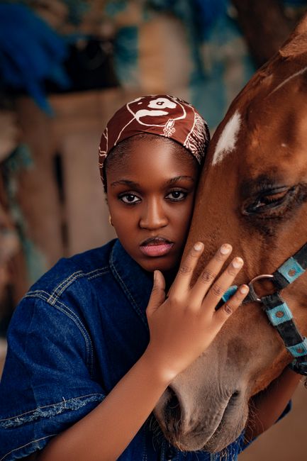 A woman in denim embraces a horse, depicting a strong bond and connection.