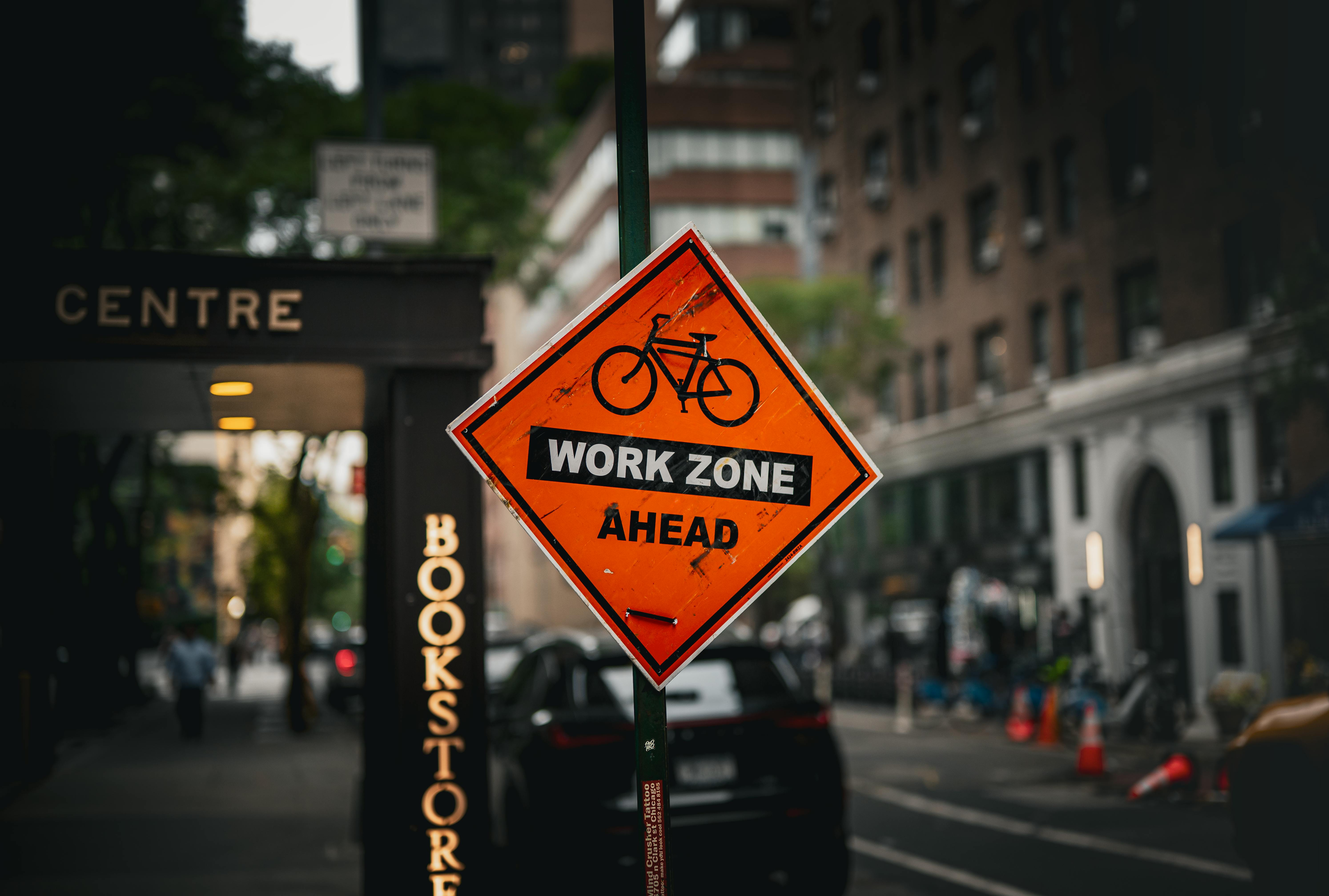 A bicycle work zone sign in a busy New York City street scene.