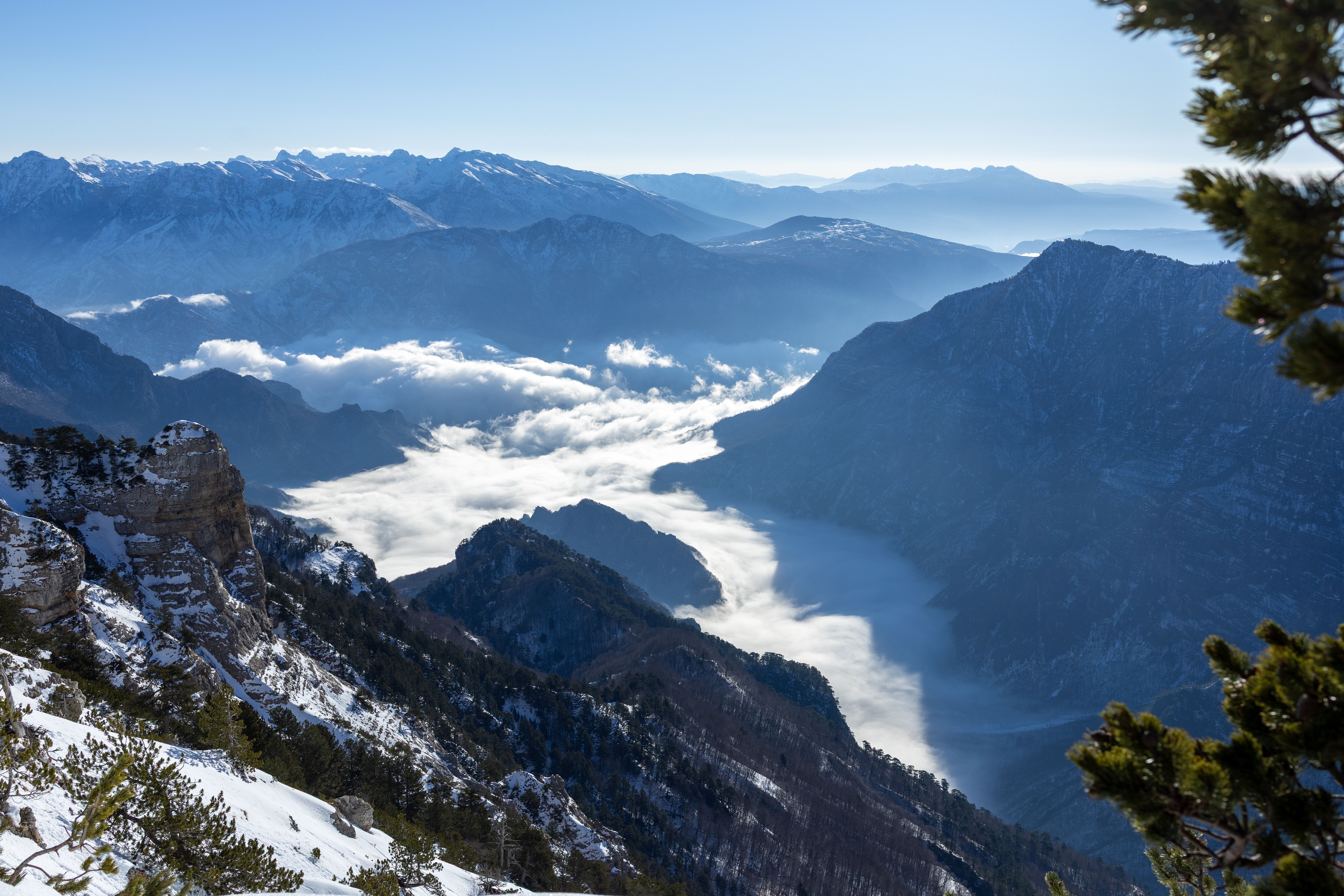 Stunning aerial view of a snowy mountain range under a clear blue sky, showcasing nature's majesty.