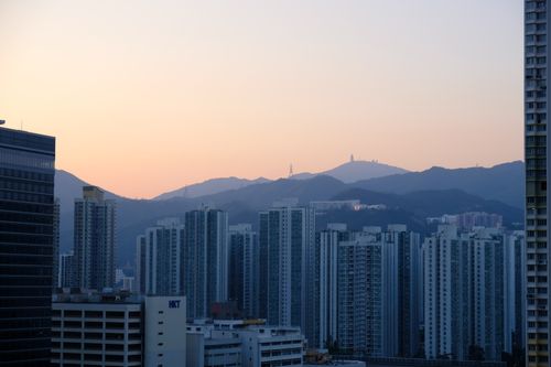 Free Panoramic view of Hong Kong's skyline at dusk with mountains in the background. Stock Photo