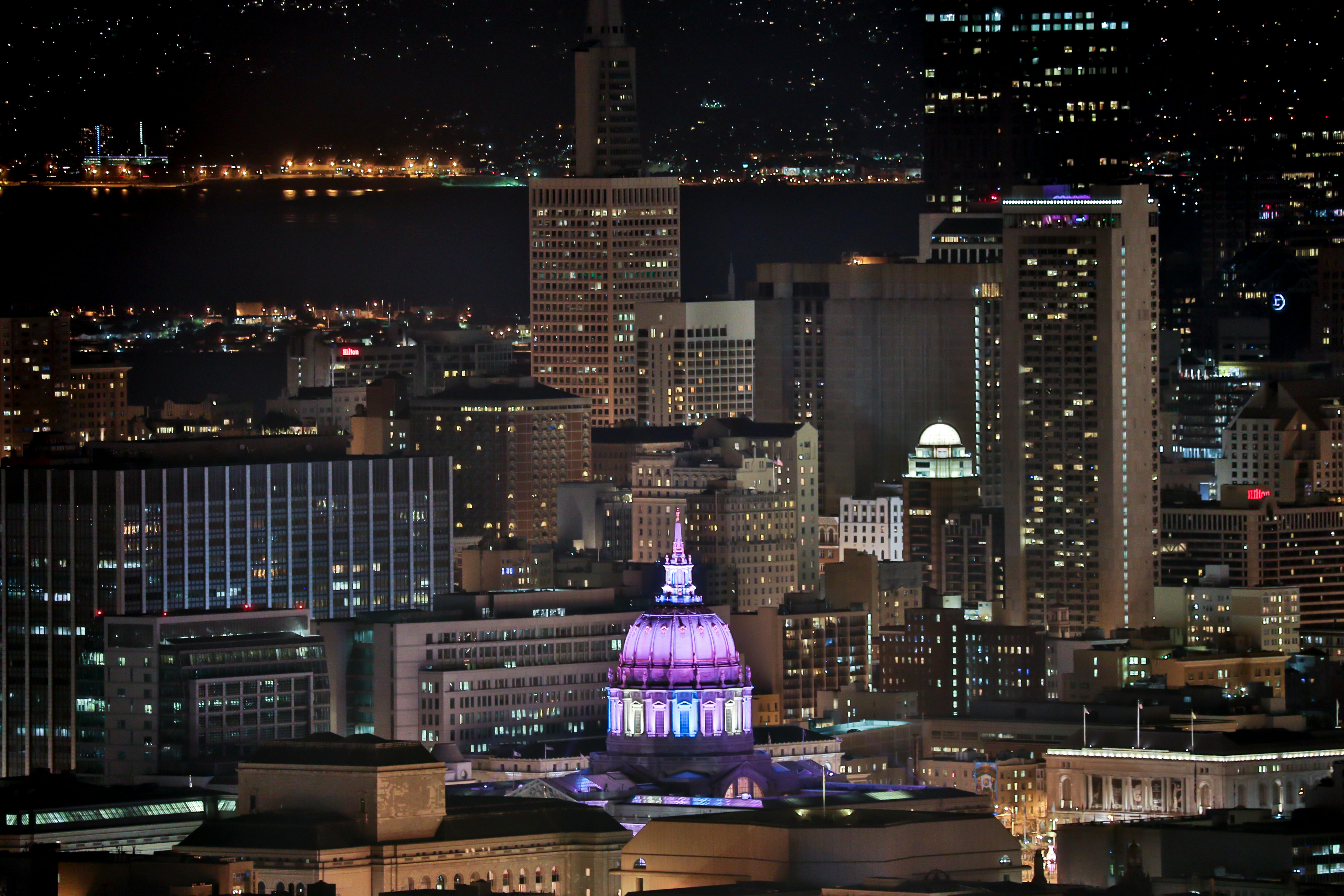 A stunning view of San Francisco skyline at night, featuring a brightly lit dome.