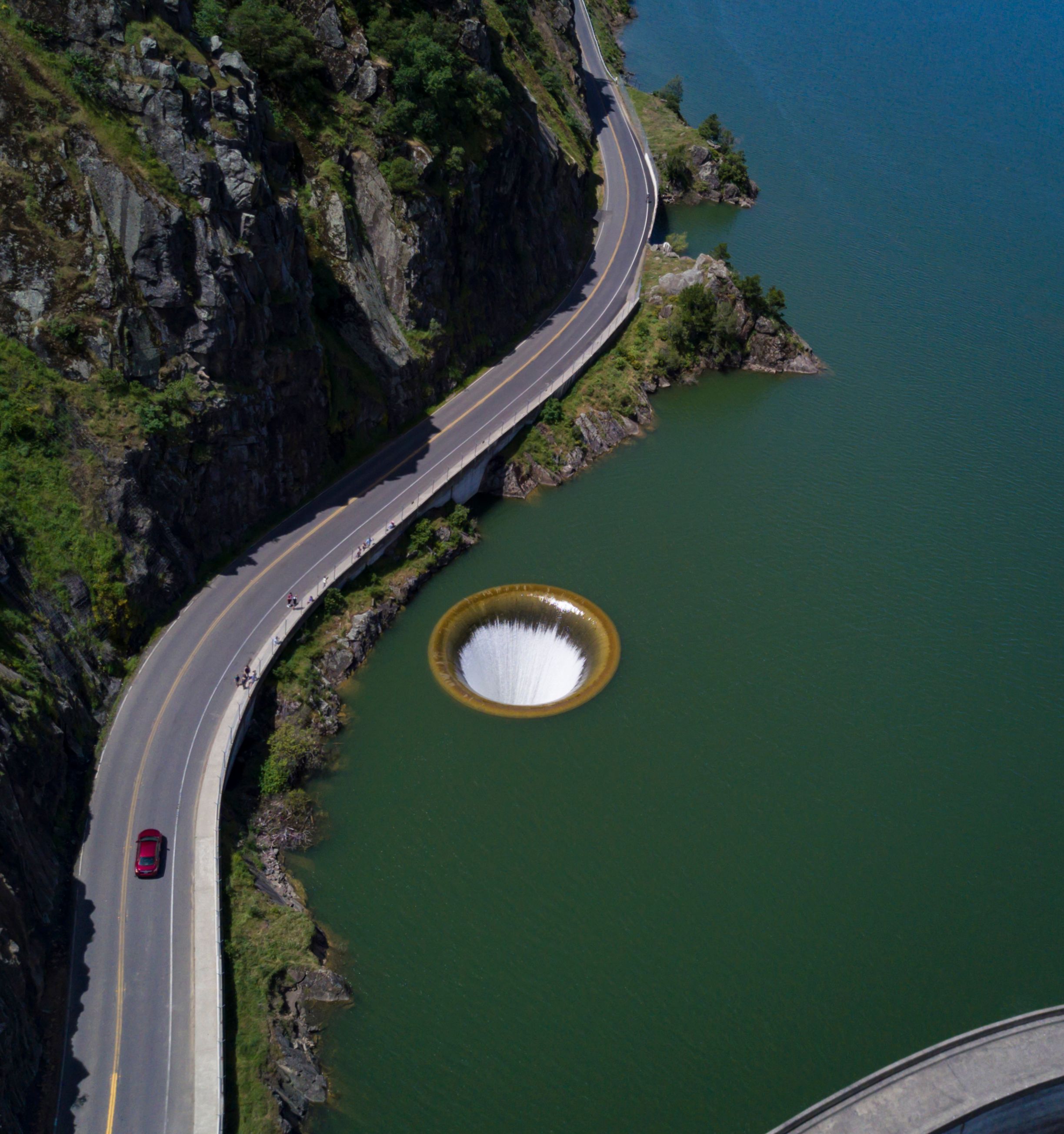 Stunning aerial shot of Lake Berryessa's Glory Hole Spillway with surrounding landscape and road.